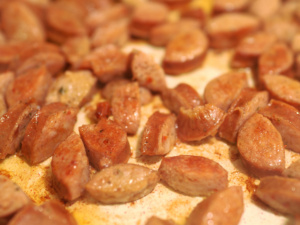 Andouille sausage browning in a skillet